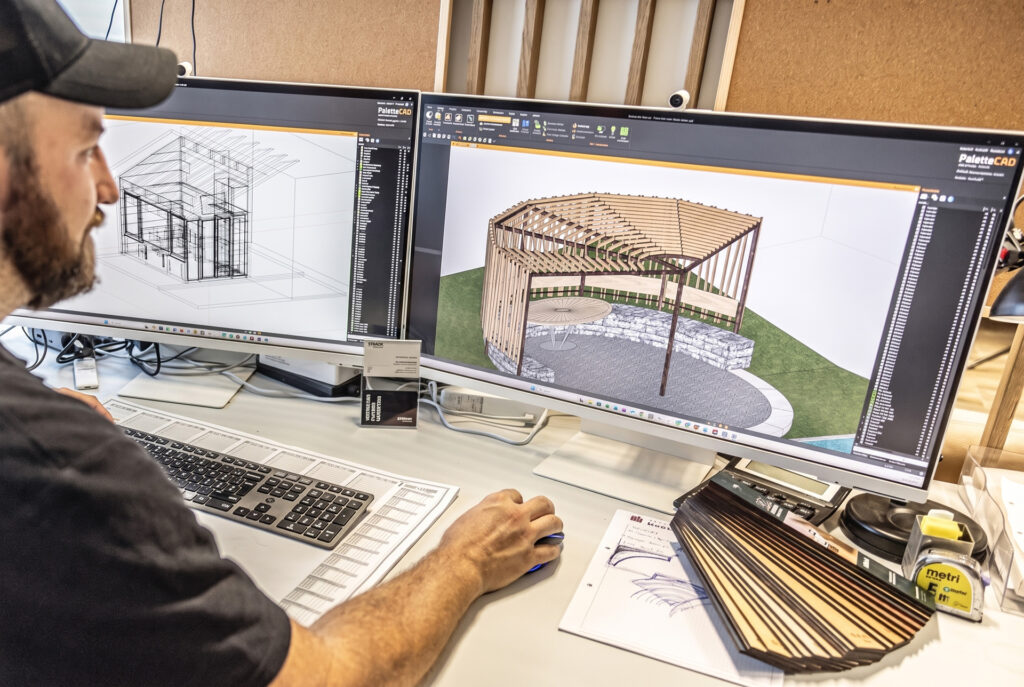 Planer von STRACK Baumanufaktur konstruiert eine Holzlaube am CAD-Arbeitsplatz mit zwei Bildschirmen