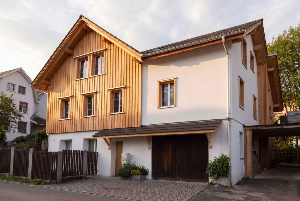 Saniertes Wohnhaus mit vertikaler Holzschalung an der Fassade
