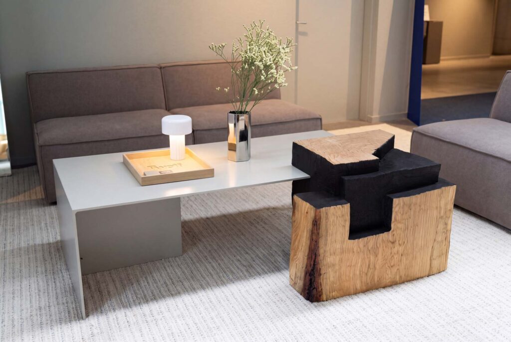 Beistelltisch aus Eiche mit geschwärzten Flächen als Einzelstück neben einem Loungetisch