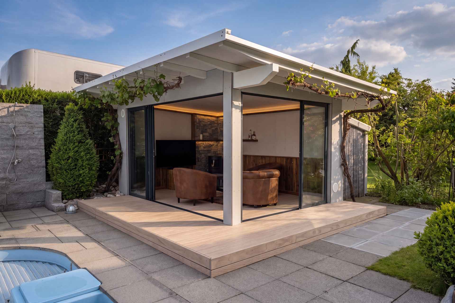 Gartenzimmer Arnegg von aussen: Holzterrasse, Schiebeverglasung und auskragendes Dach am Pool