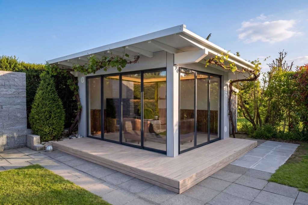 Gartenzimmer in Arnegg mit weissem Flachdach und geöffneter Schiebeverglasung zum Sitzplatz
