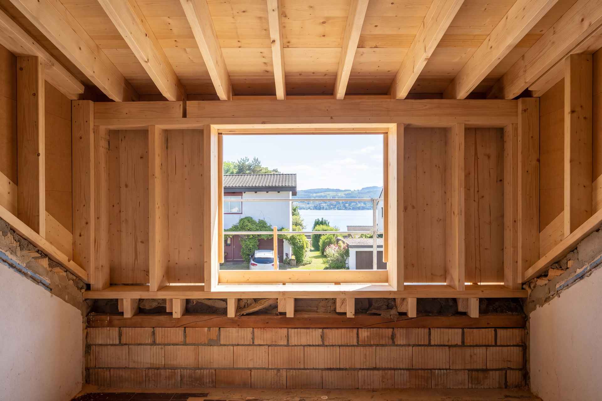 Gaubenkonstruktion im Rohbau: Holzrahmen mit Fensteröffnung und Ausblick