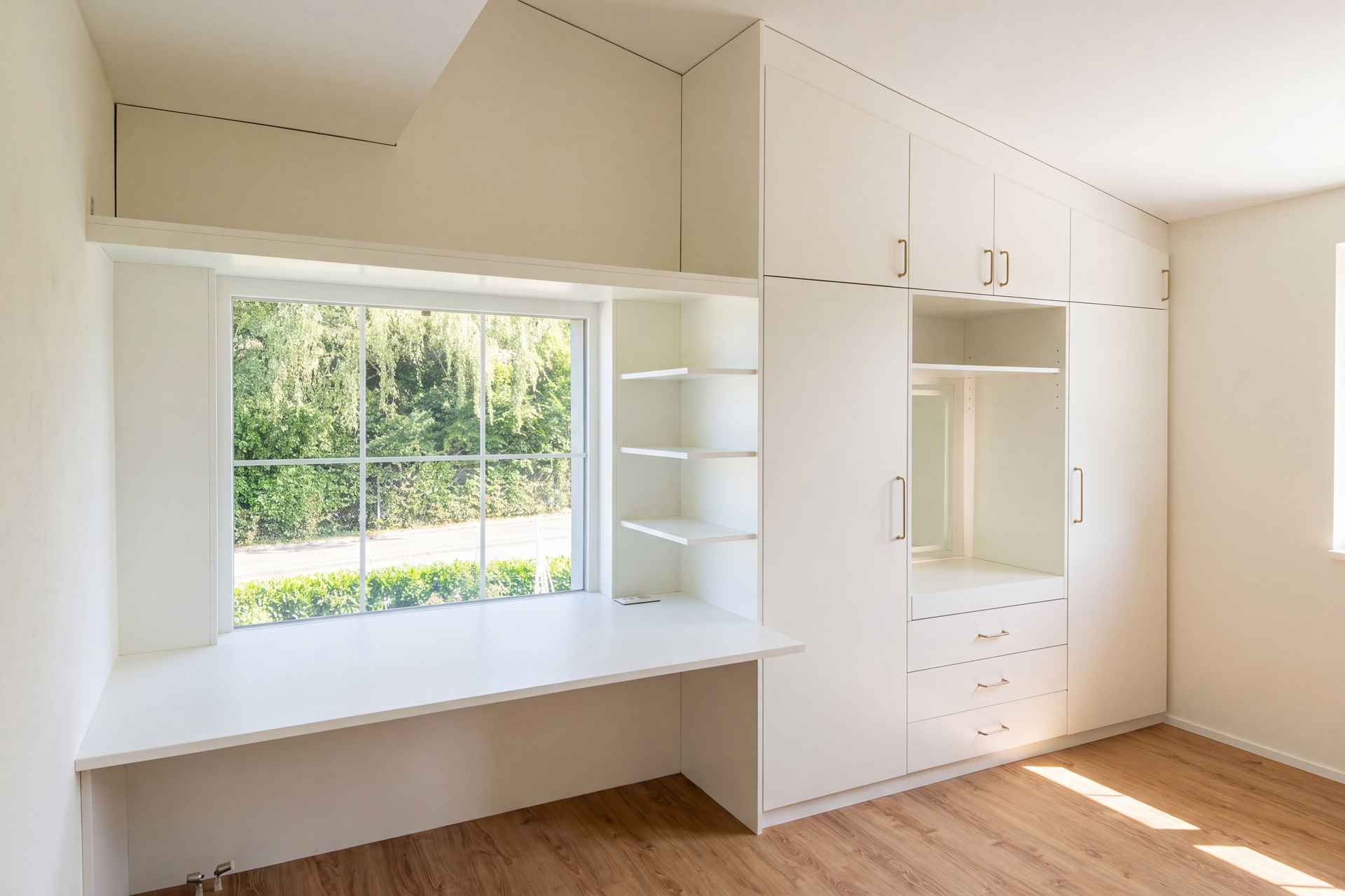 Einbauschrank mit Sitzbank und Regalen um das Dachfenster