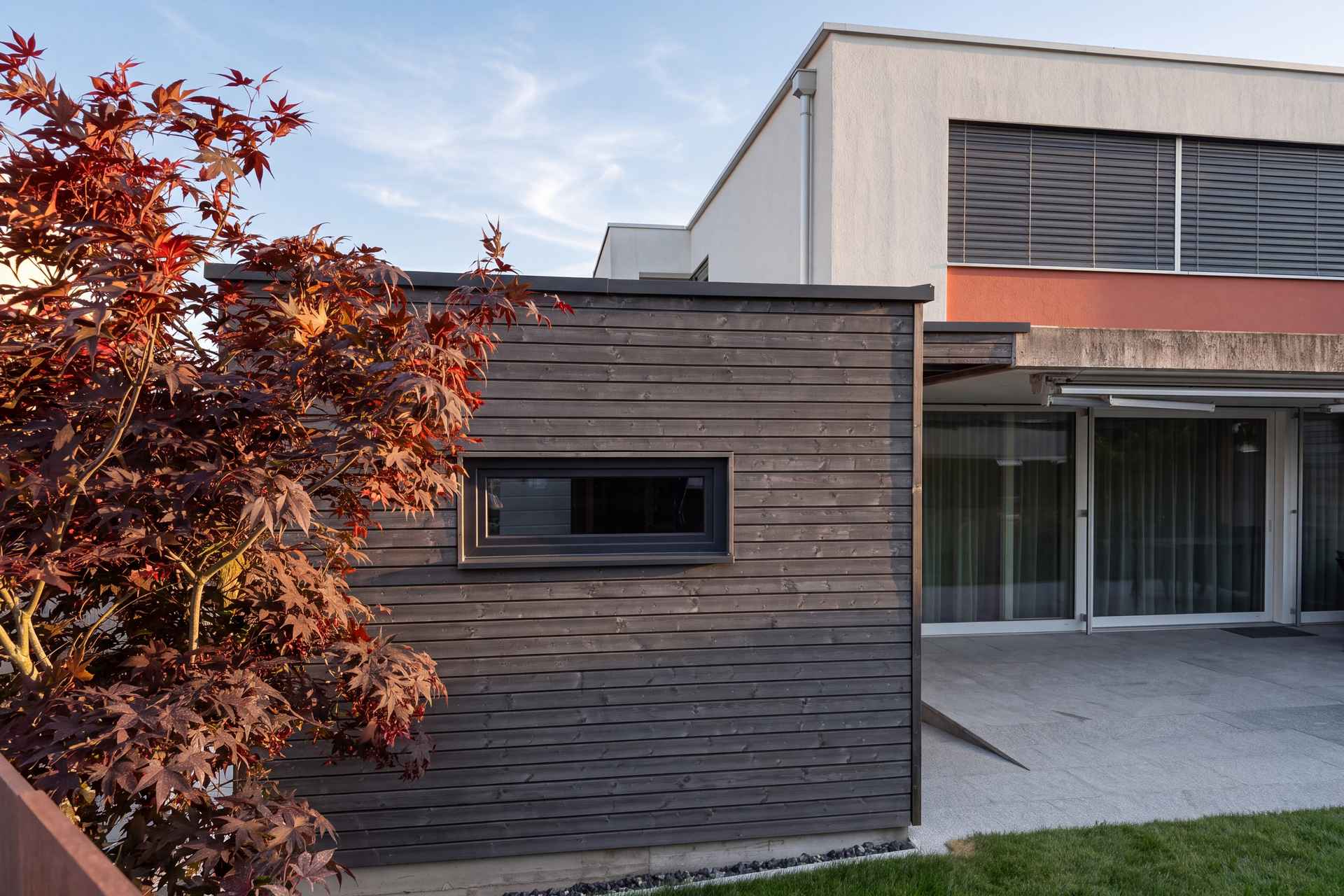 Gartenhaus in dunkel lasierter Lärche mit liegendem Fensterband