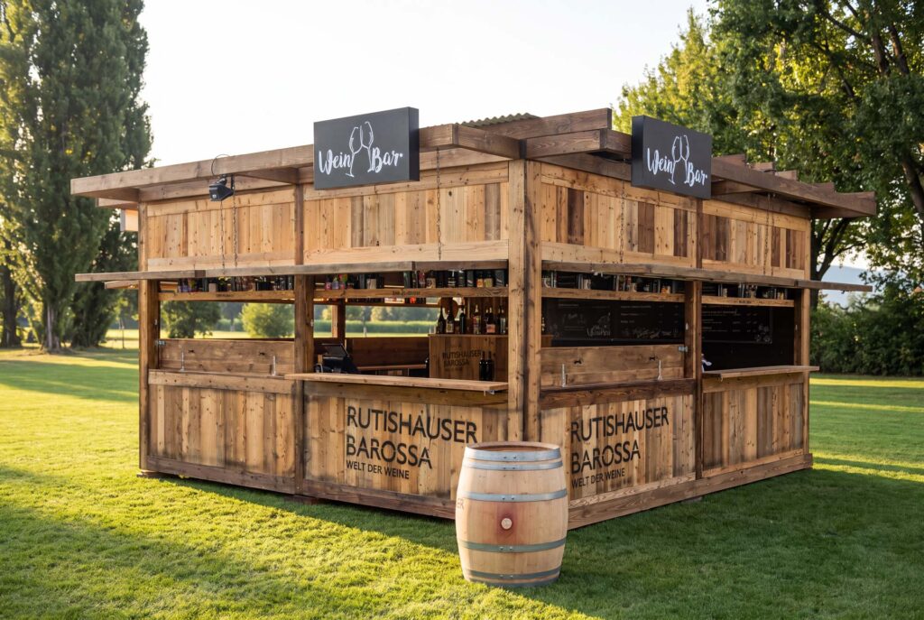 Weinbar aus Altholz auf dem Festgelände, aufgeklappte Fensterläden und Holzfass davor